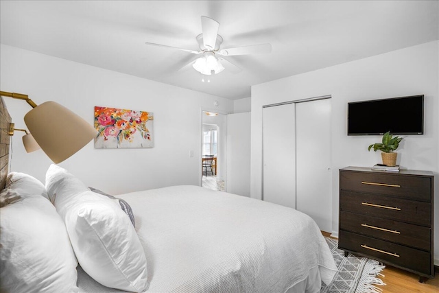 bedroom with light wood-type flooring, a closet, and ceiling fan