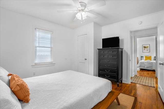 bedroom with ceiling fan, dark hardwood / wood-style floors, and ornamental molding