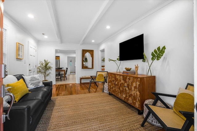 living room with hardwood / wood-style floors, beamed ceiling, and ornamental molding