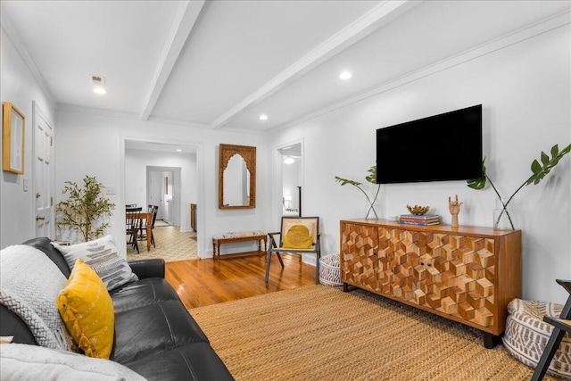 living room with beam ceiling, wood-type flooring, and crown molding