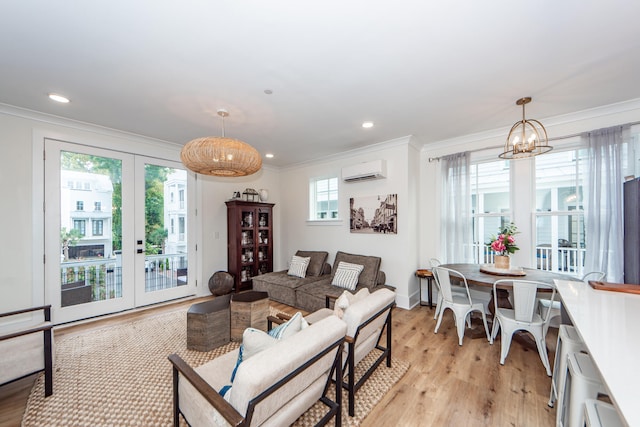 living room featuring a chandelier, crown molding, a wall mounted air conditioner, and light hardwood / wood-style floors