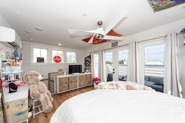 bedroom with dark wood-type flooring, a wall mounted air conditioner, access to exterior, and ceiling fan