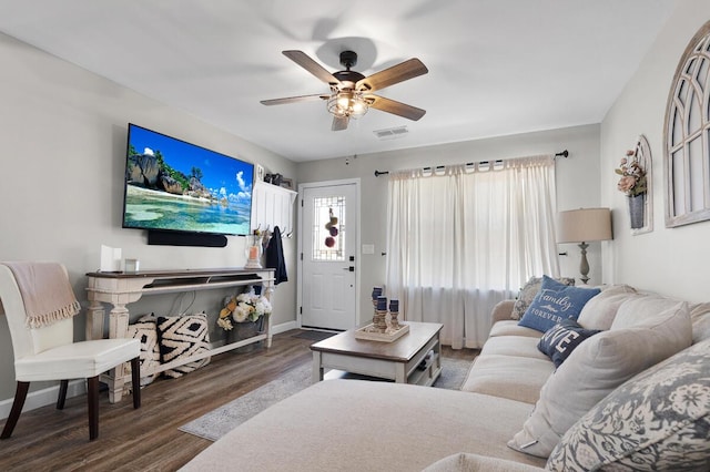 living room featuring baseboards, dark wood-type flooring, visible vents, and a ceiling fan