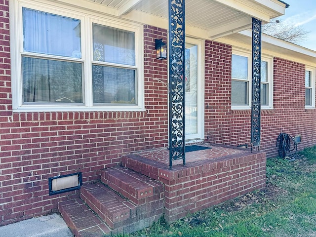 doorway to property featuring crawl space and brick siding