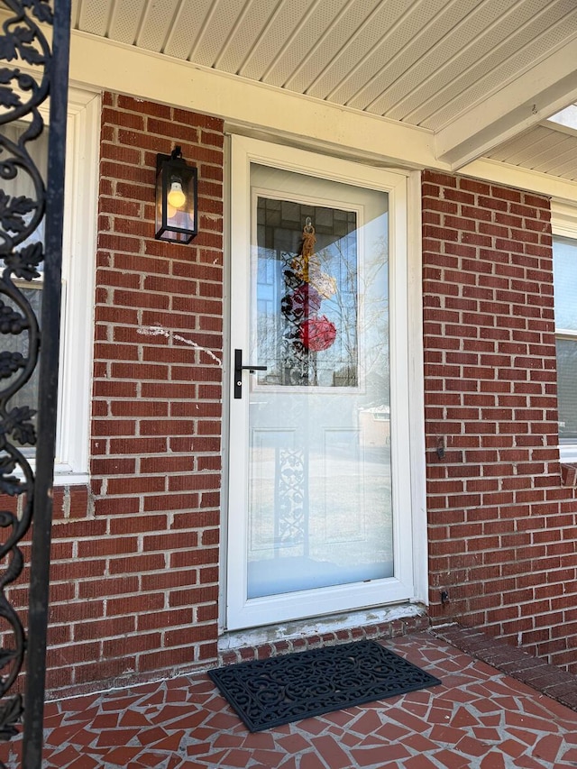 entrance to property featuring brick siding