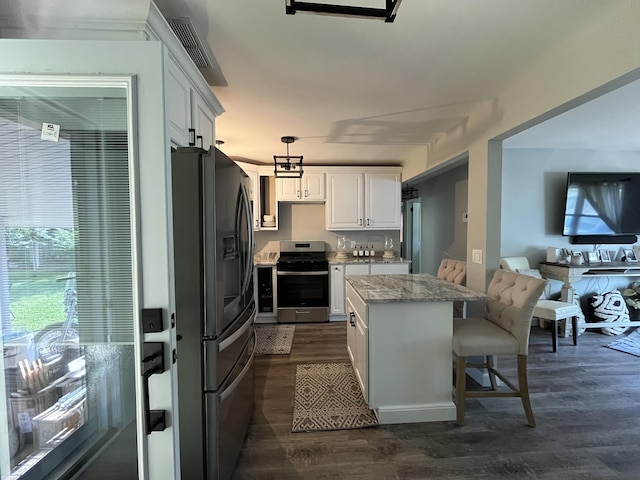 kitchen featuring a center island, stainless steel electric range oven, hanging light fixtures, white cabinets, and fridge with ice dispenser