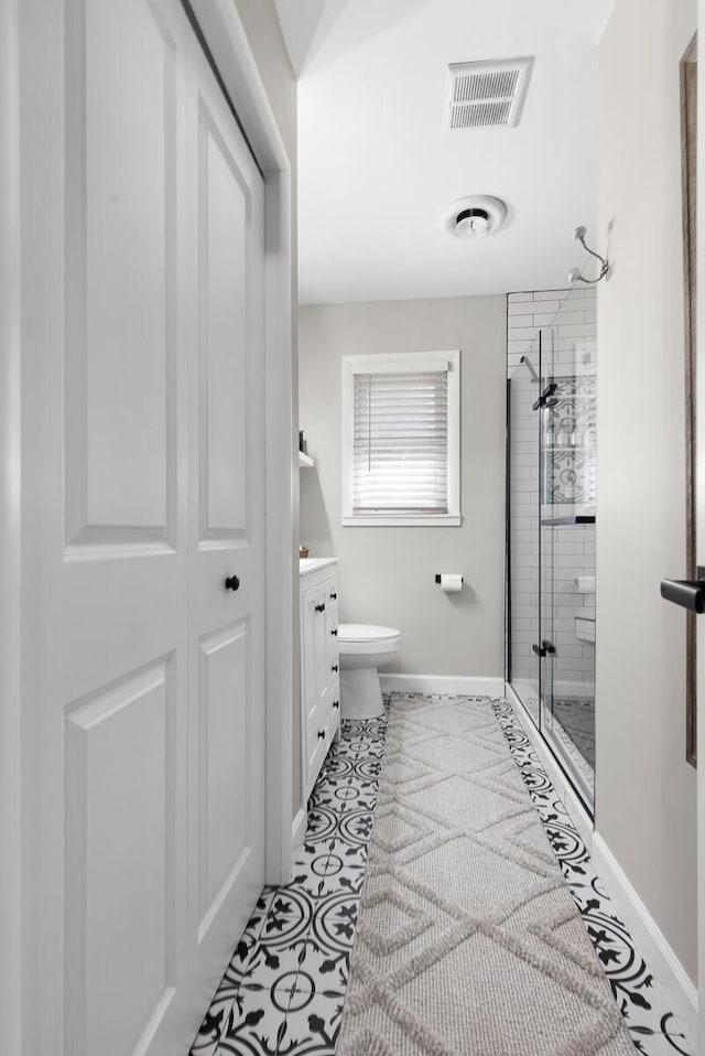 full bath with visible vents, toilet, vanity, a shower stall, and a closet