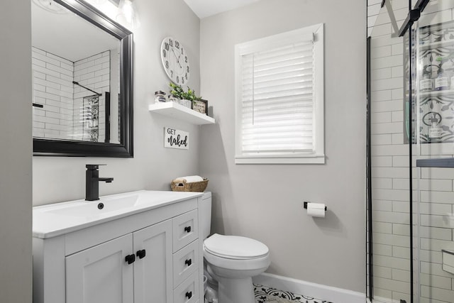 full bathroom featuring a shower stall, baseboards, vanity, and toilet