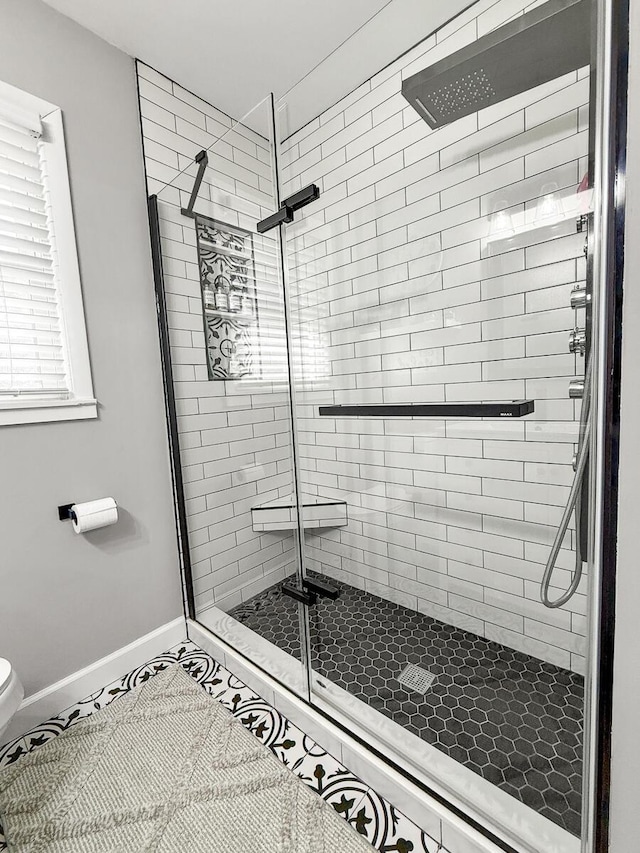 full bathroom featuring tile patterned flooring, a shower stall, toilet, and baseboards