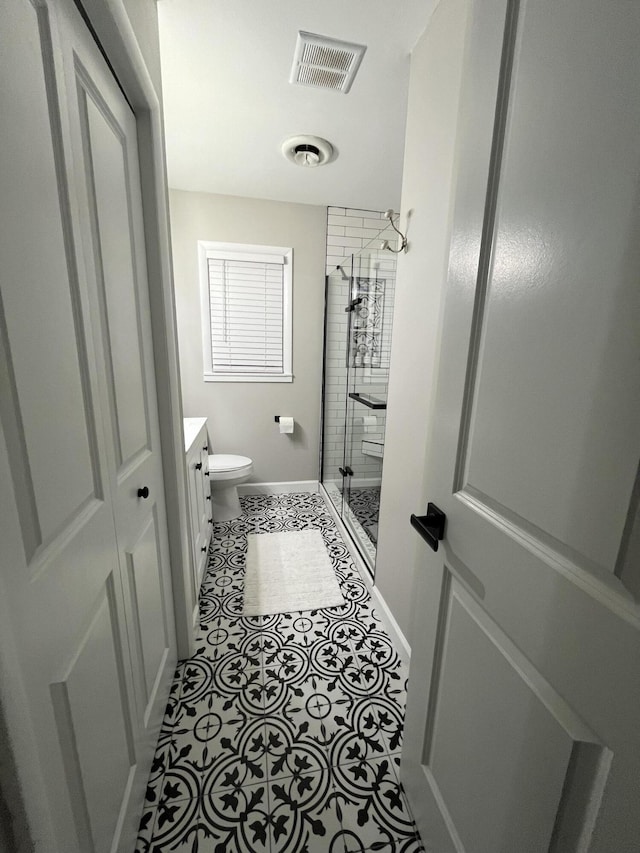 bathroom featuring visible vents, toilet, a stall shower, vanity, and baseboards