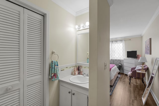 bathroom with connected bathroom, crown molding, wood finished floors, a closet, and vanity