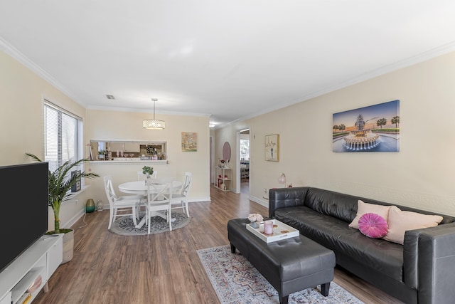 living room with baseboards, wood finished floors, and ornamental molding