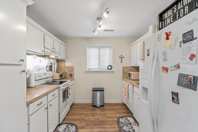 kitchen featuring backsplash, dark wood-style floors, plenty of natural light, white cabinets, and white appliances