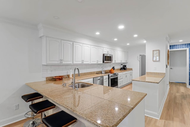 4 Beach Club Villas, Isle Of Palms, SC 29451 - kitchen with stainless steel appliances, a peninsula, a sink, tasteful backsplash, and white cabinetry