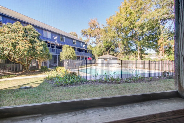 view of pool featuring a lawn, fence, and a fenced in pool