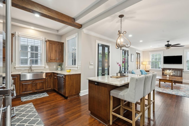 kitchen with hanging light fixtures, ceiling fan with notable chandelier, dark hardwood / wood-style flooring, sink, and stainless steel dishwasher