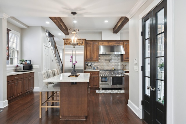 kitchen featuring a kitchen island, dark hardwood / wood-style floors, beamed ceiling, extractor fan, and high quality appliances