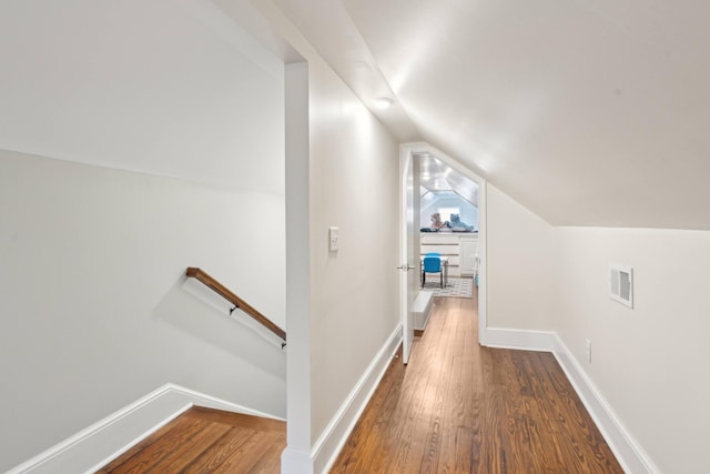 hallway with lofted ceiling and hardwood / wood-style floors