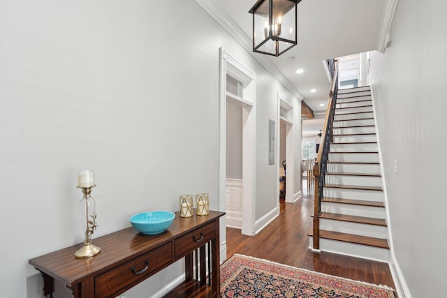 entryway featuring crown molding, dark hardwood / wood-style flooring, and a notable chandelier