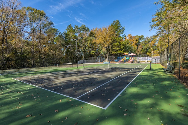 view of sport court featuring playground community and fence