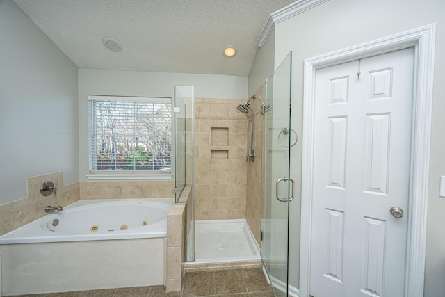 bathroom featuring a stall shower, a jetted tub, a textured ceiling, and tile patterned floors