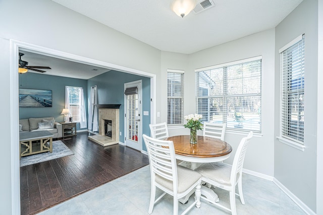 dining area with a healthy amount of sunlight, baseboards, a fireplace, and visible vents