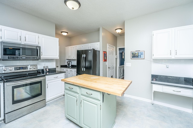 kitchen featuring appliances with stainless steel finishes, a center island, white cabinets, and tasteful backsplash