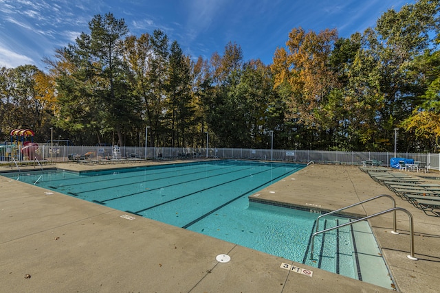 community pool featuring fence and a patio