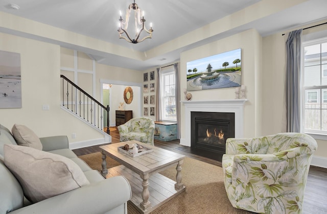 living room with dark hardwood / wood-style flooring, plenty of natural light, and a chandelier