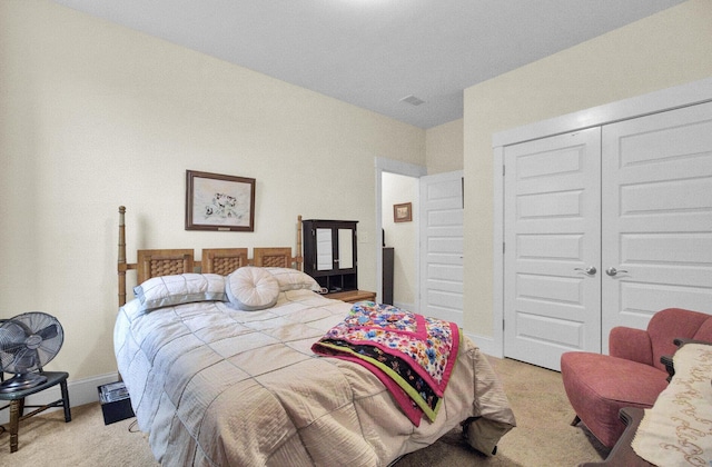 bedroom with light colored carpet and a closet