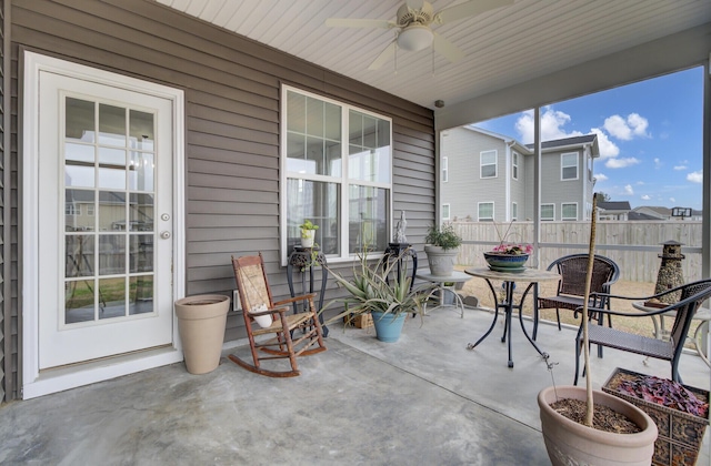 sunroom / solarium with ceiling fan and a patio area