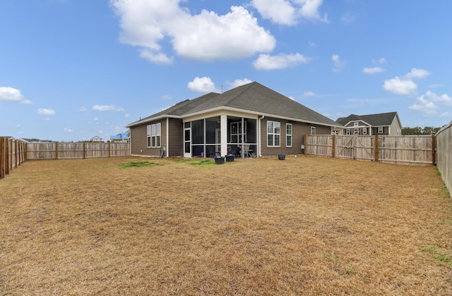 back of property featuring a lawn and a sunroom