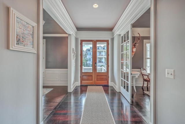 entryway featuring wainscoting, ornamental molding, dark wood finished floors, and french doors