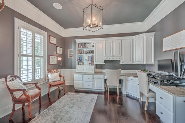 office area featuring built in desk, dark wood-type flooring, and crown molding