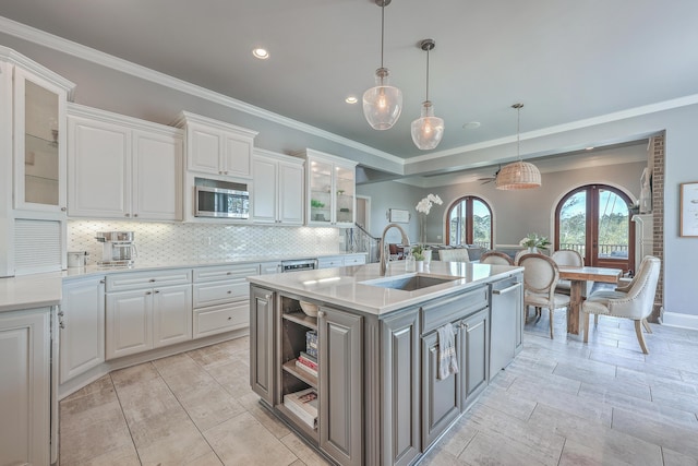 kitchen featuring stainless steel appliances, white cabinets, light countertops, and a sink