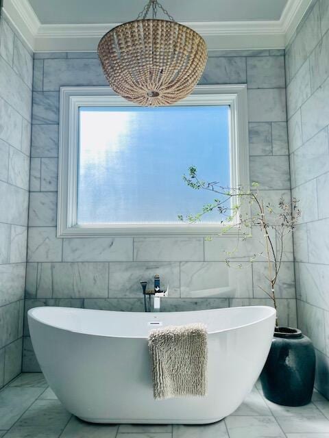 bathroom featuring marble finish floor, a freestanding tub, and crown molding