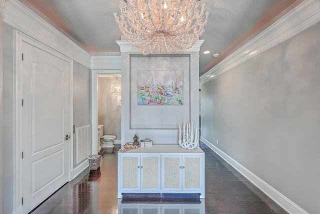 interior space featuring baseboards, visible vents, ornamental molding, and dark wood finished floors