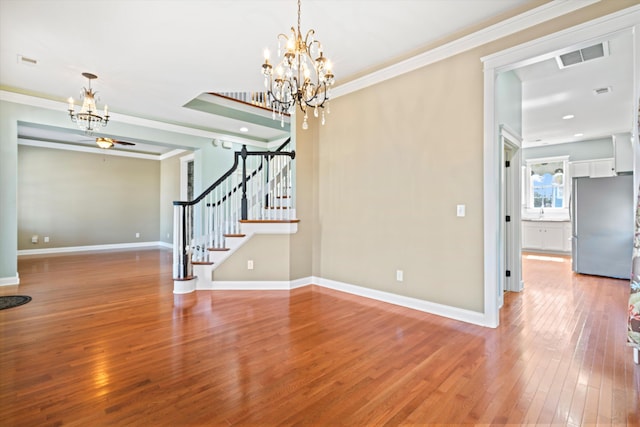 unfurnished room with visible vents, baseboards, stairs, hardwood / wood-style floors, and crown molding