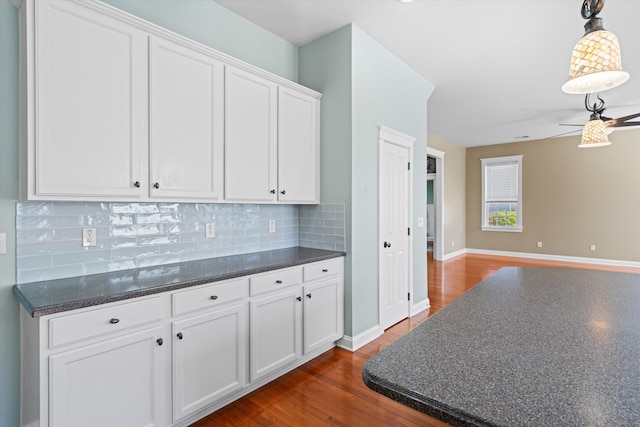 kitchen with white cabinetry, open floor plan, decorative backsplash, dark wood-style floors, and decorative light fixtures