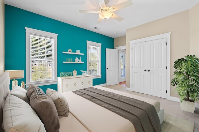 bedroom with carpet flooring, a ceiling fan, visible vents, baseboards, and a closet