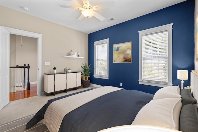 carpeted bedroom featuring multiple windows, visible vents, and baseboards