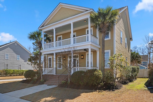 view of front facade featuring covered porch, ceiling fan, and fence