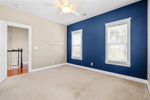 unfurnished room featuring baseboards, visible vents, a wealth of natural light, and carpet flooring