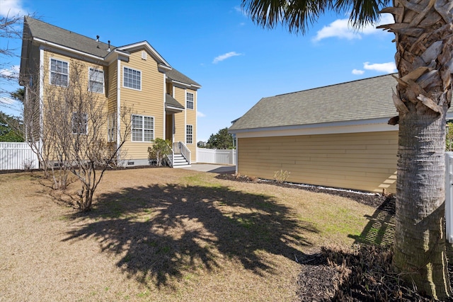 rear view of property with crawl space, a shingled roof, and fence