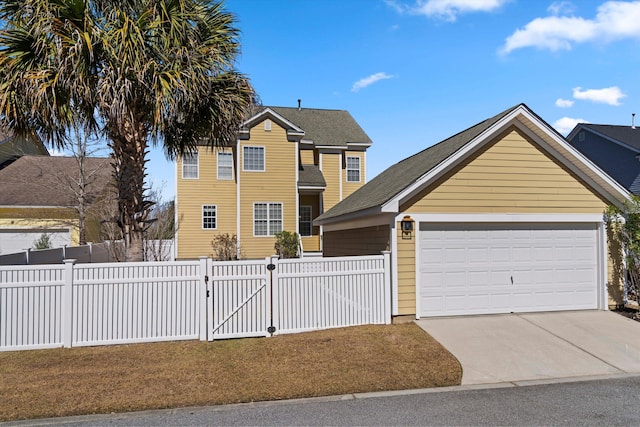 view of front facade featuring a gate, fence, concrete driveway, and an attached garage