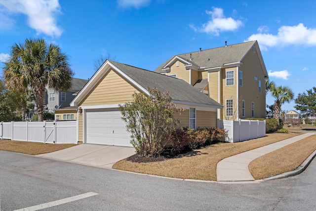 view of front of property with a garage, a gate, fence, and concrete driveway