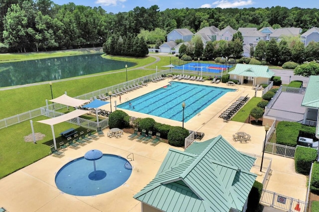 community pool featuring a patio area, fence, and a water view