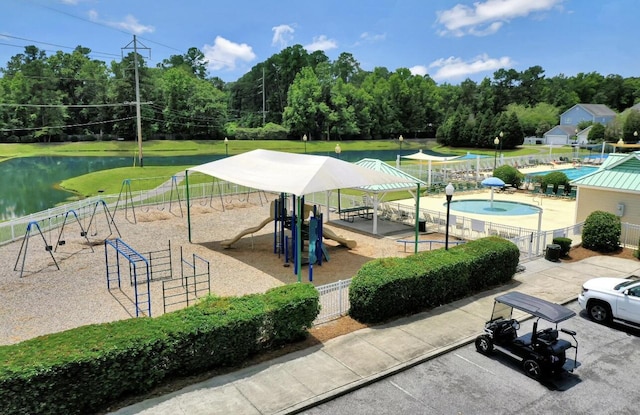 surrounding community with playground community, a water view, and fence