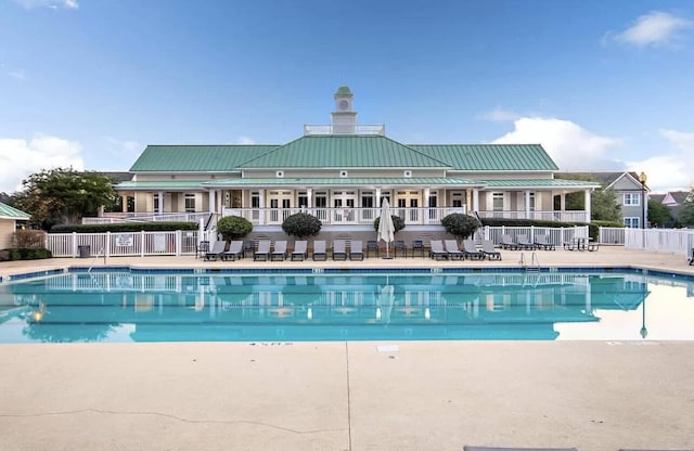 community pool with a patio area and fence