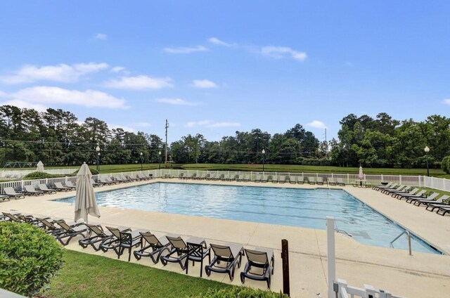 pool with a patio and fence